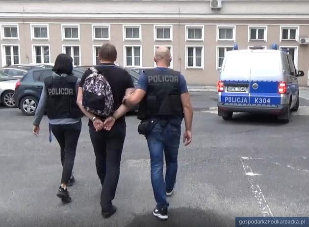 Policja prowadzi jednego z podejrzanych menedżerów. Fot. Policja